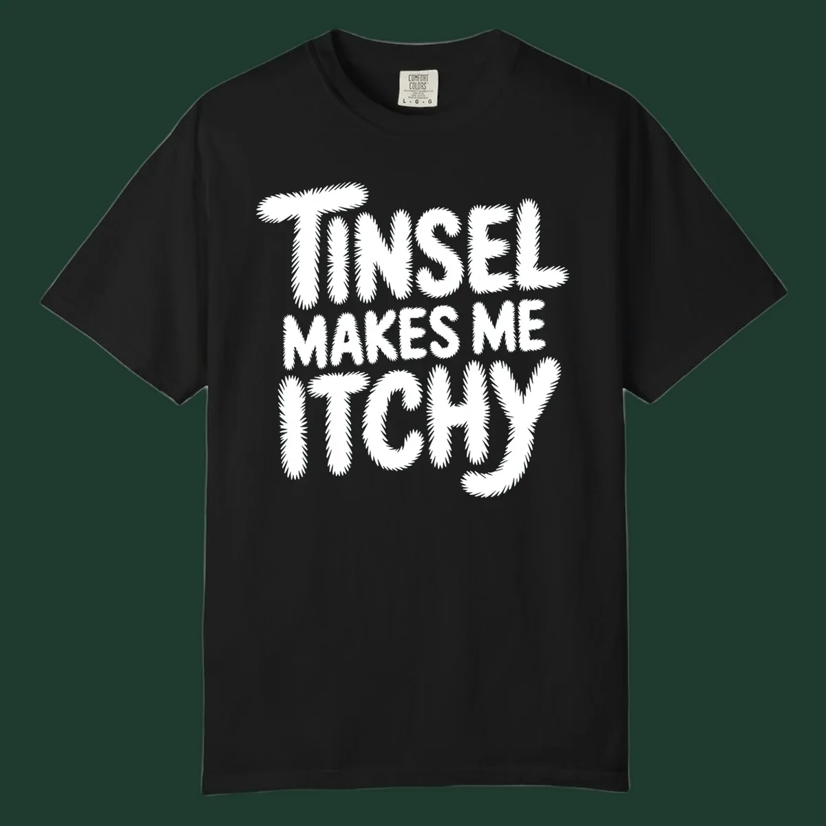Text design reading "Tinsel Makes Me Itchy" in a fuzzy font.