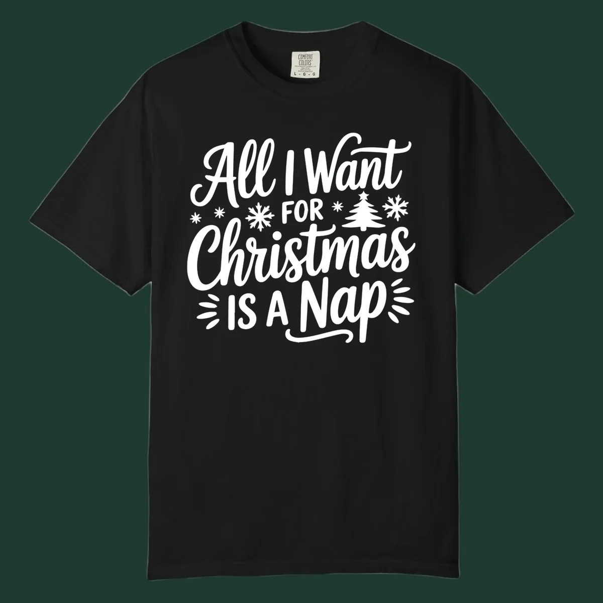 All I Want For Christmas Is A Nap typographic design with snowflakes and a Christmas tree.