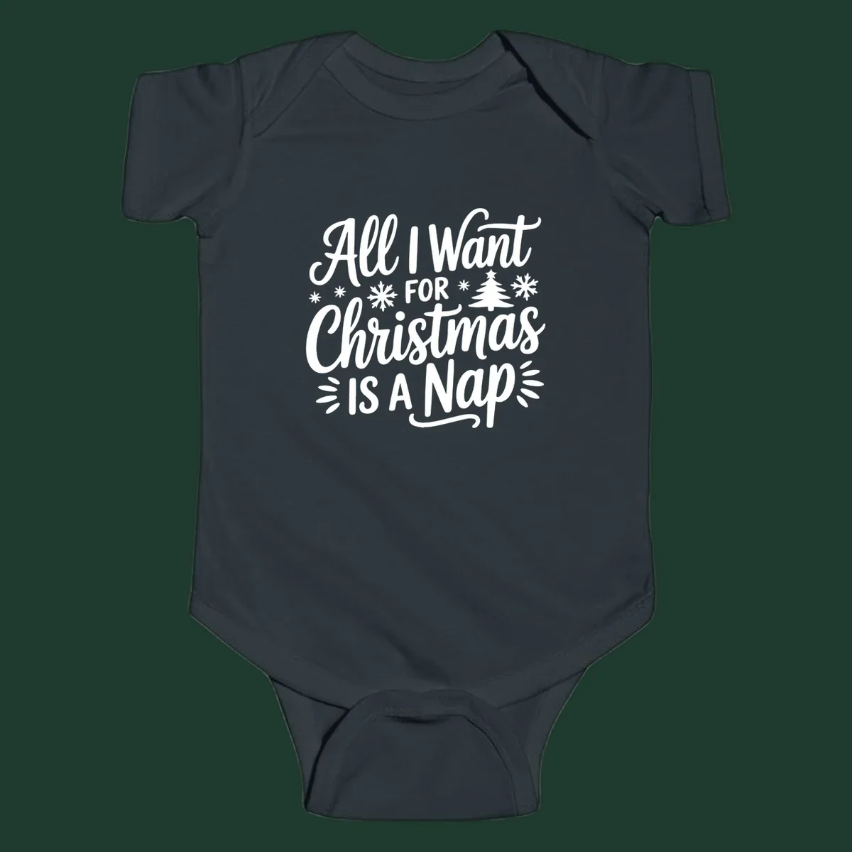 All I Want For Christmas Is A Nap typographic design with snowflakes and a Christmas tree.