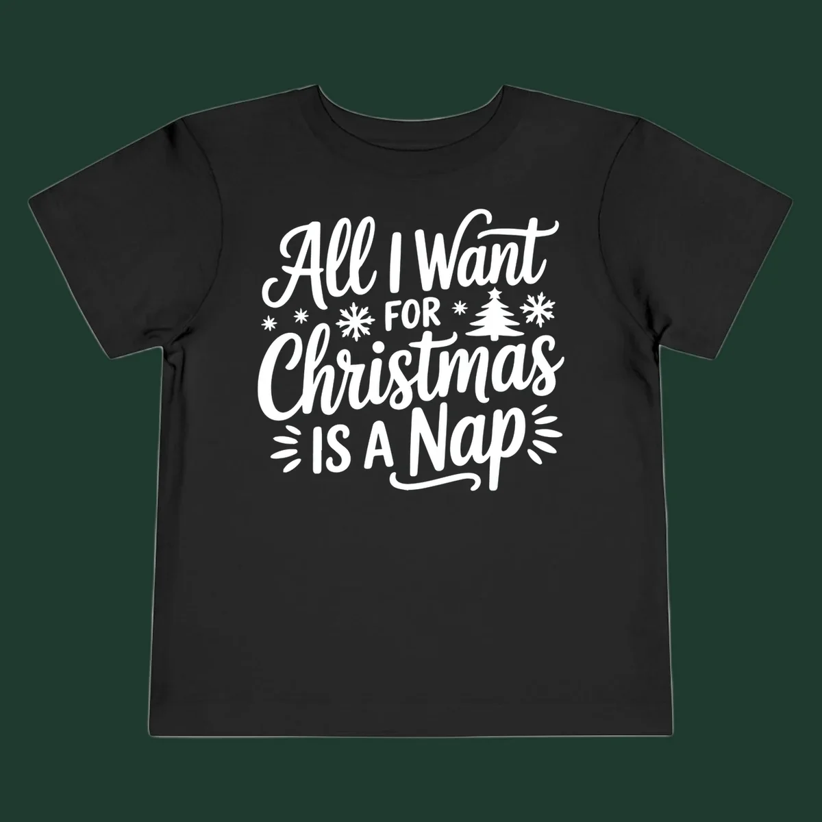 All I Want For Christmas Is A Nap typographic design with snowflakes and a Christmas tree.