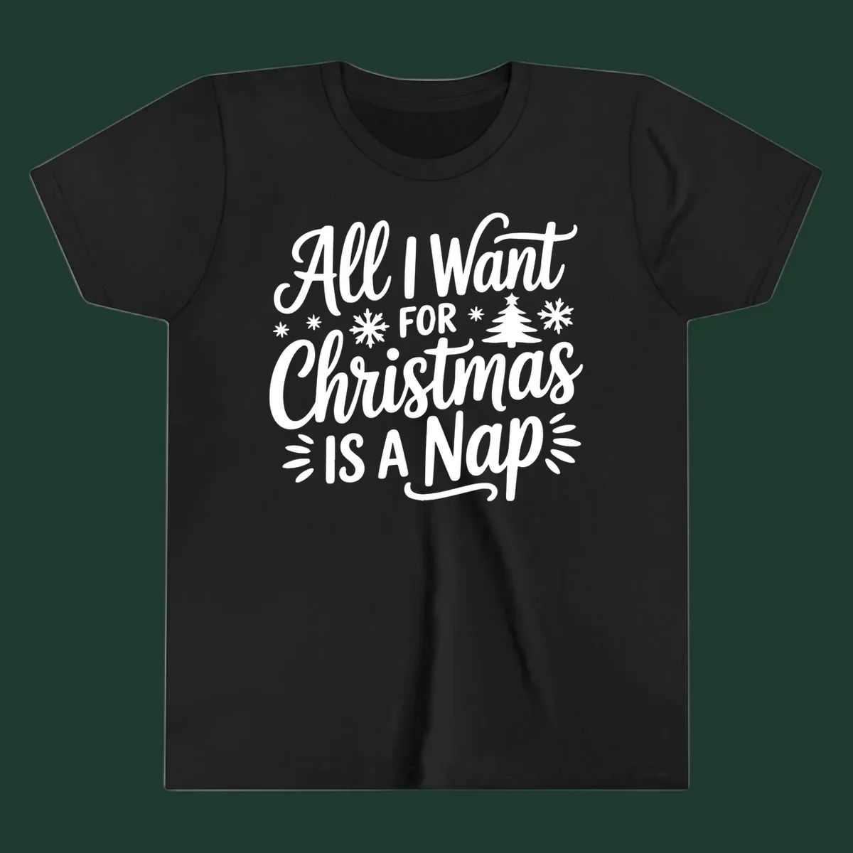 All I Want For Christmas Is A Nap typographic design with snowflakes and a Christmas tree.
