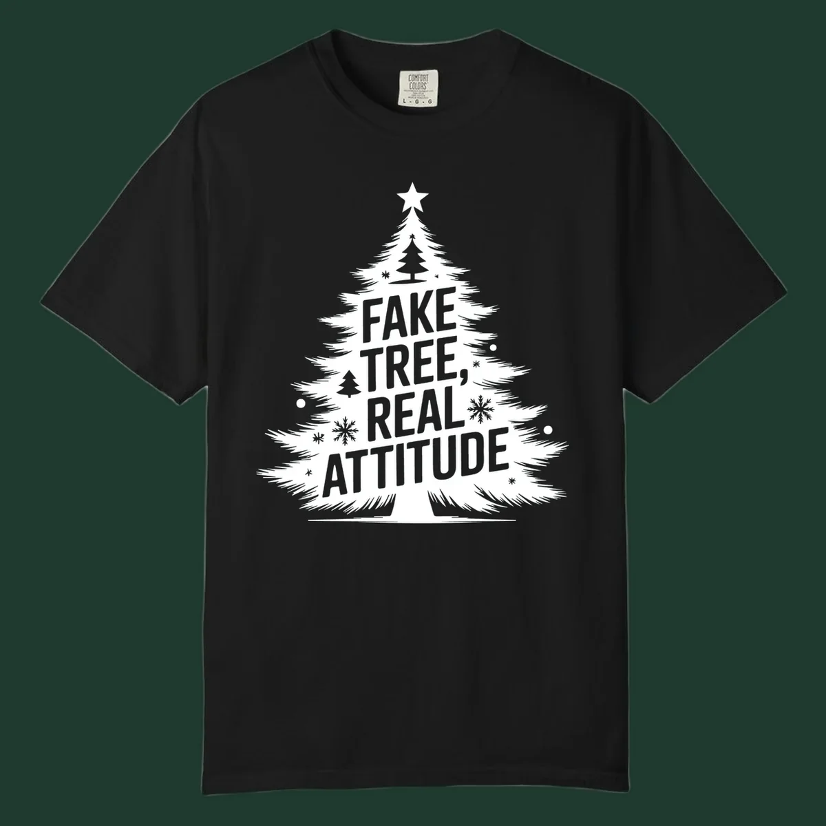 Christmas tree graphic with text 'FAKE TREE, REAL ATTITUDE' and snowflake accents.