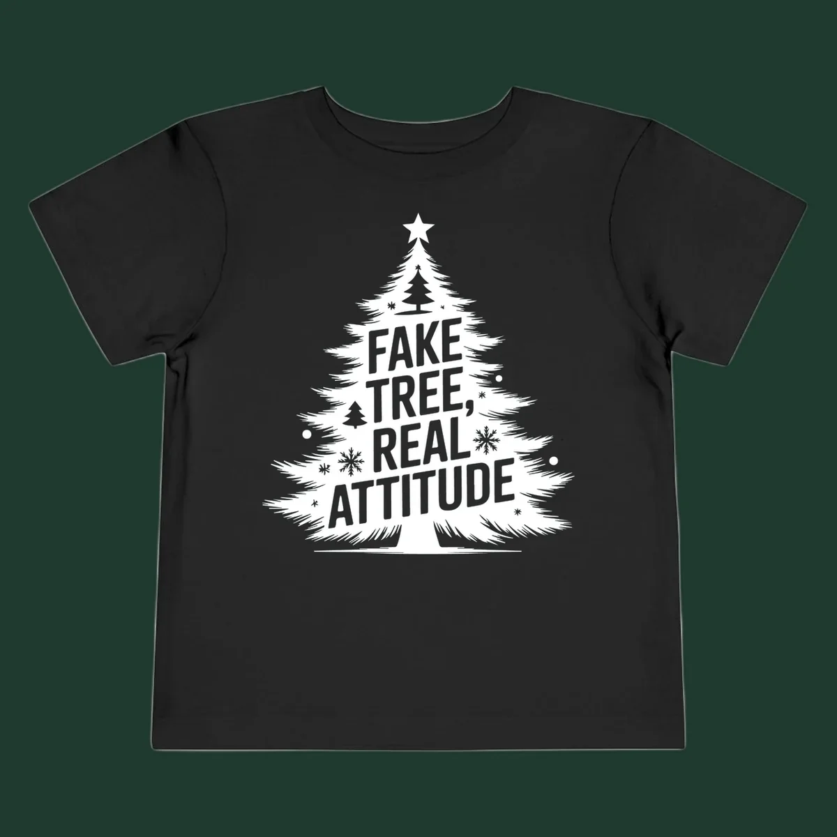 Christmas tree graphic with text 'FAKE TREE, REAL ATTITUDE' and snowflake accents.