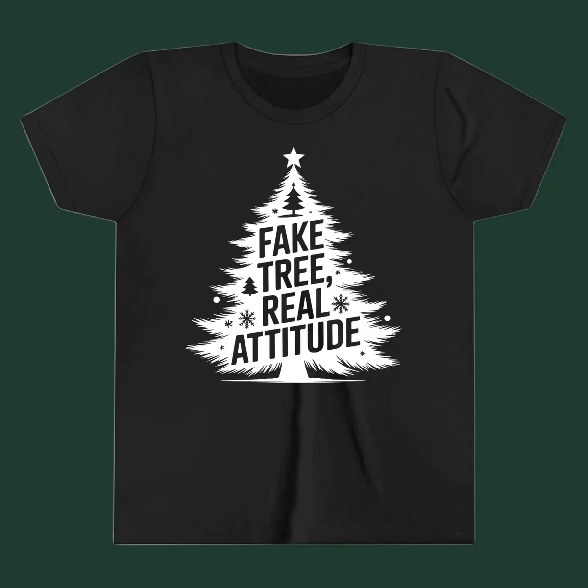 Christmas tree graphic with text 'FAKE TREE, REAL ATTITUDE' and snowflake accents.
