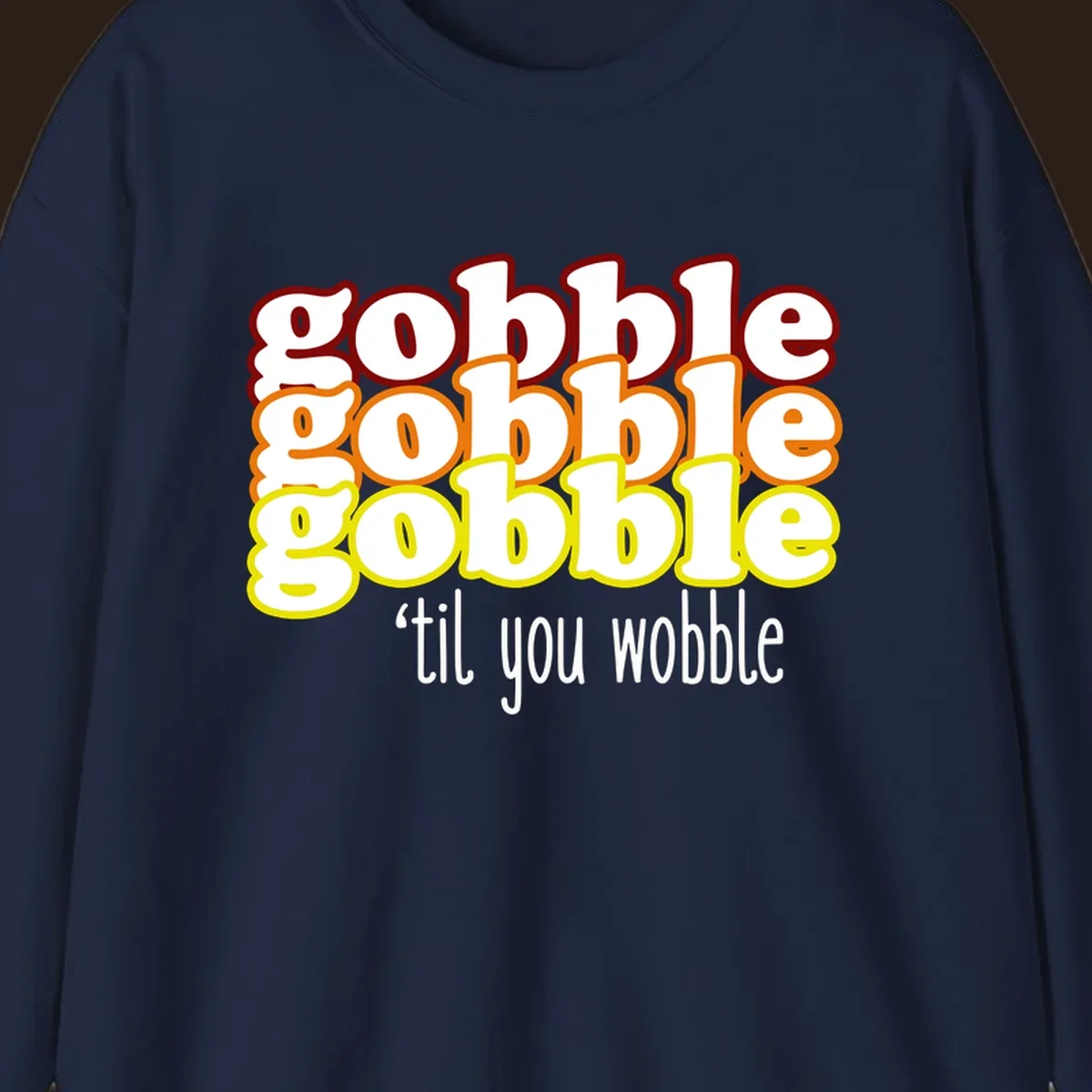 Gobble 'til you wobble thanksgiving text design with stacked gobble words in red, orange, yellow and white text below.