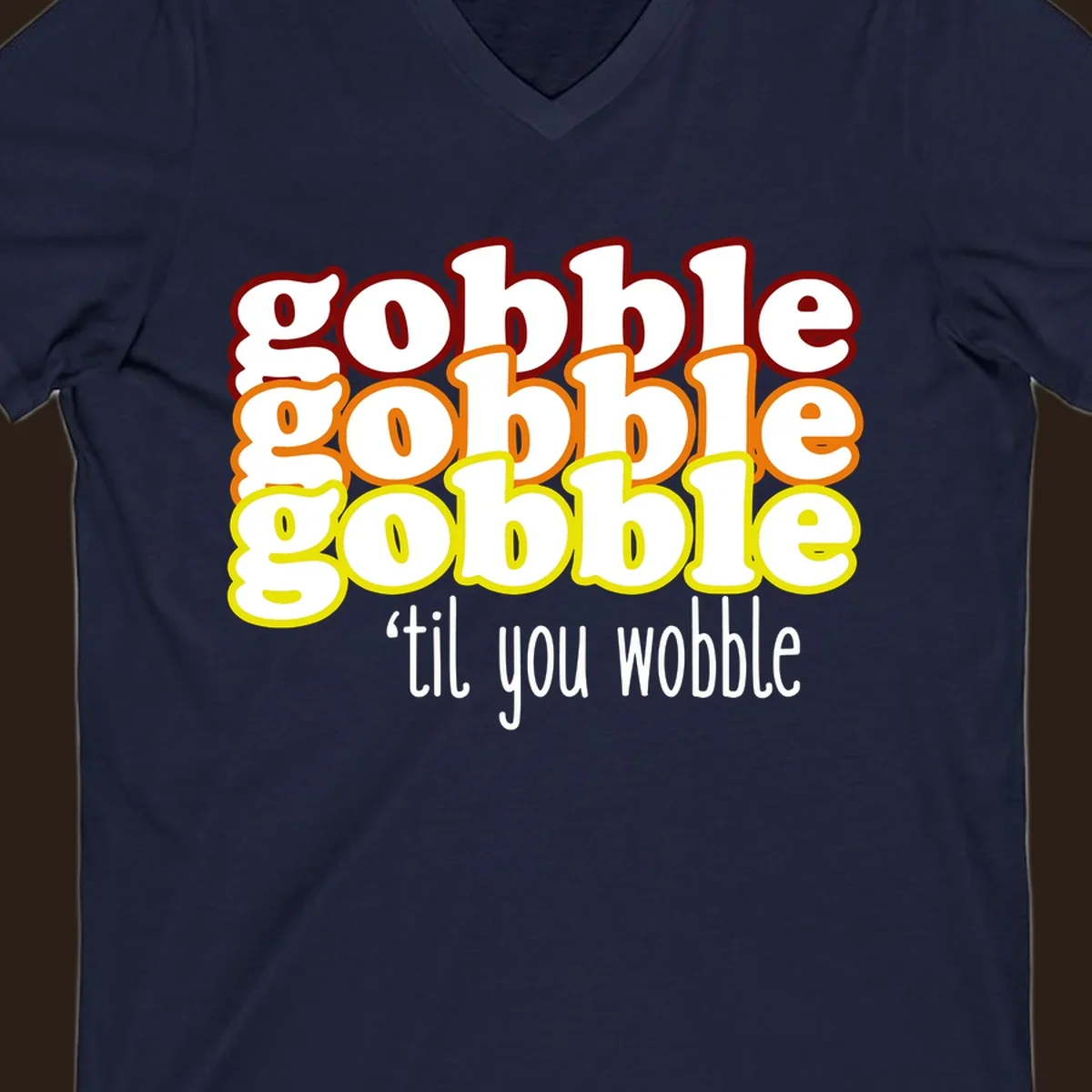 Gobble 'til you wobble thanksgiving text design with stacked gobble words in red, orange, yellow and white text below.
