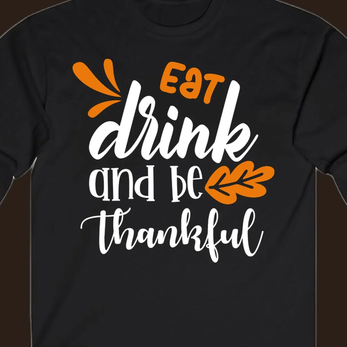 Eat Drink and Be Thankful Thanksgiving text and leaf graphic