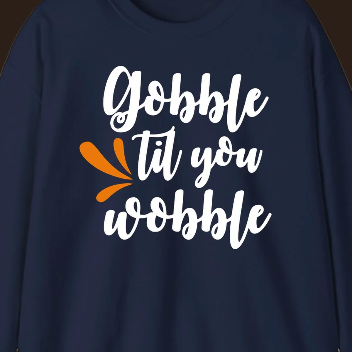 Gobble 'til you wobble Thanksgiving phrase with orange turkey feather illustrations.