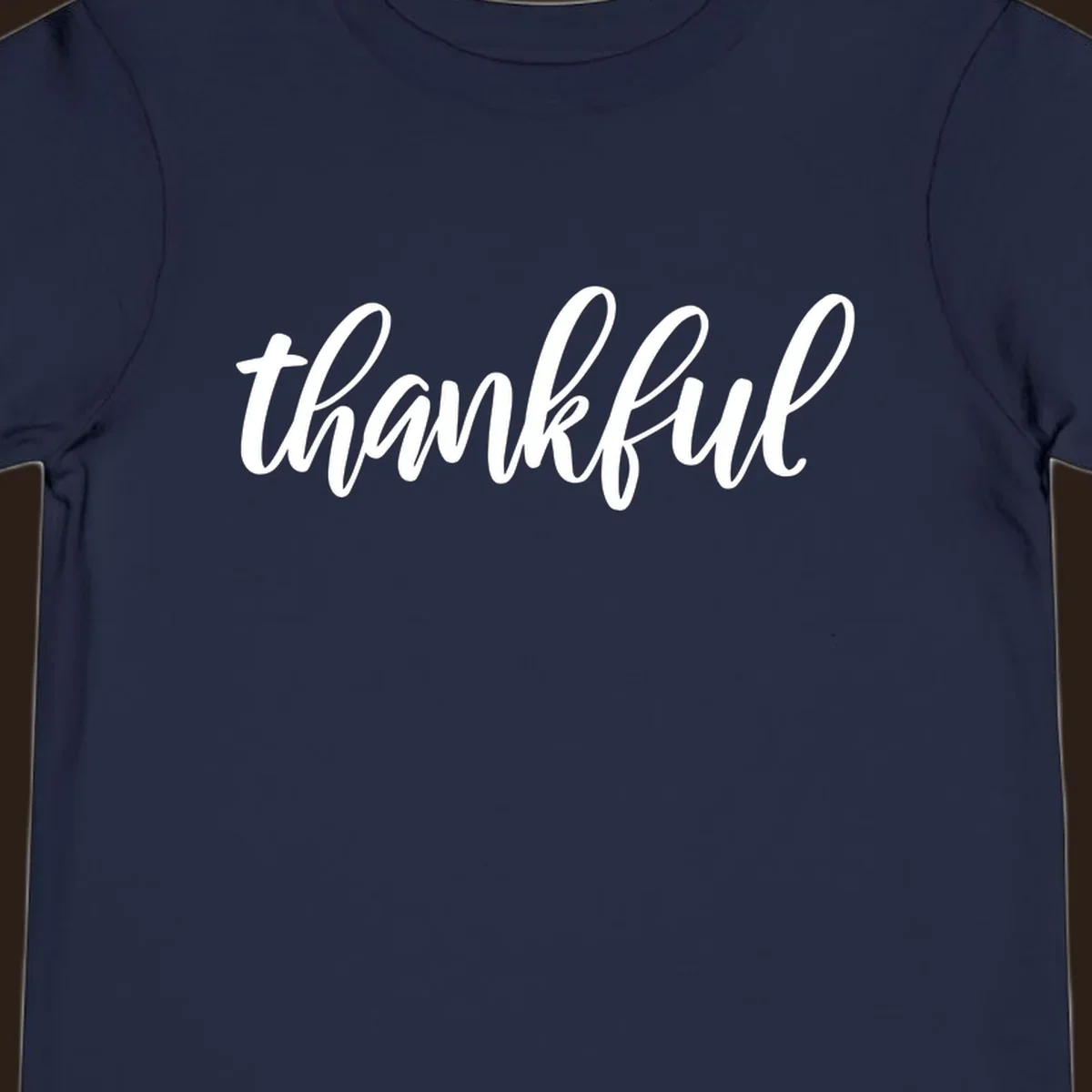 White script text spelling 'thankful' on a black background, representing thankful script word art.