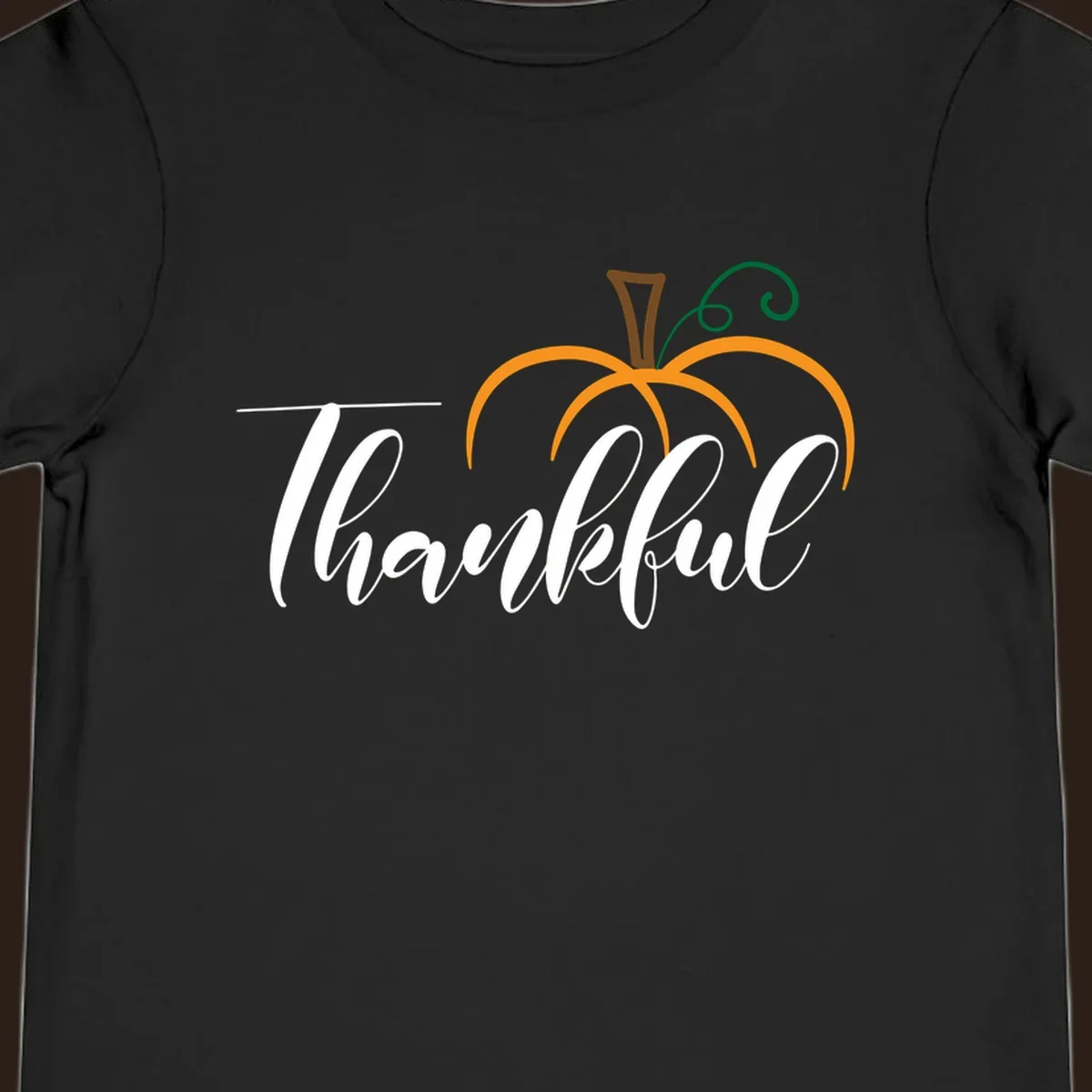 White script text 'Thankful' with a stylized orange pumpkin illustration.