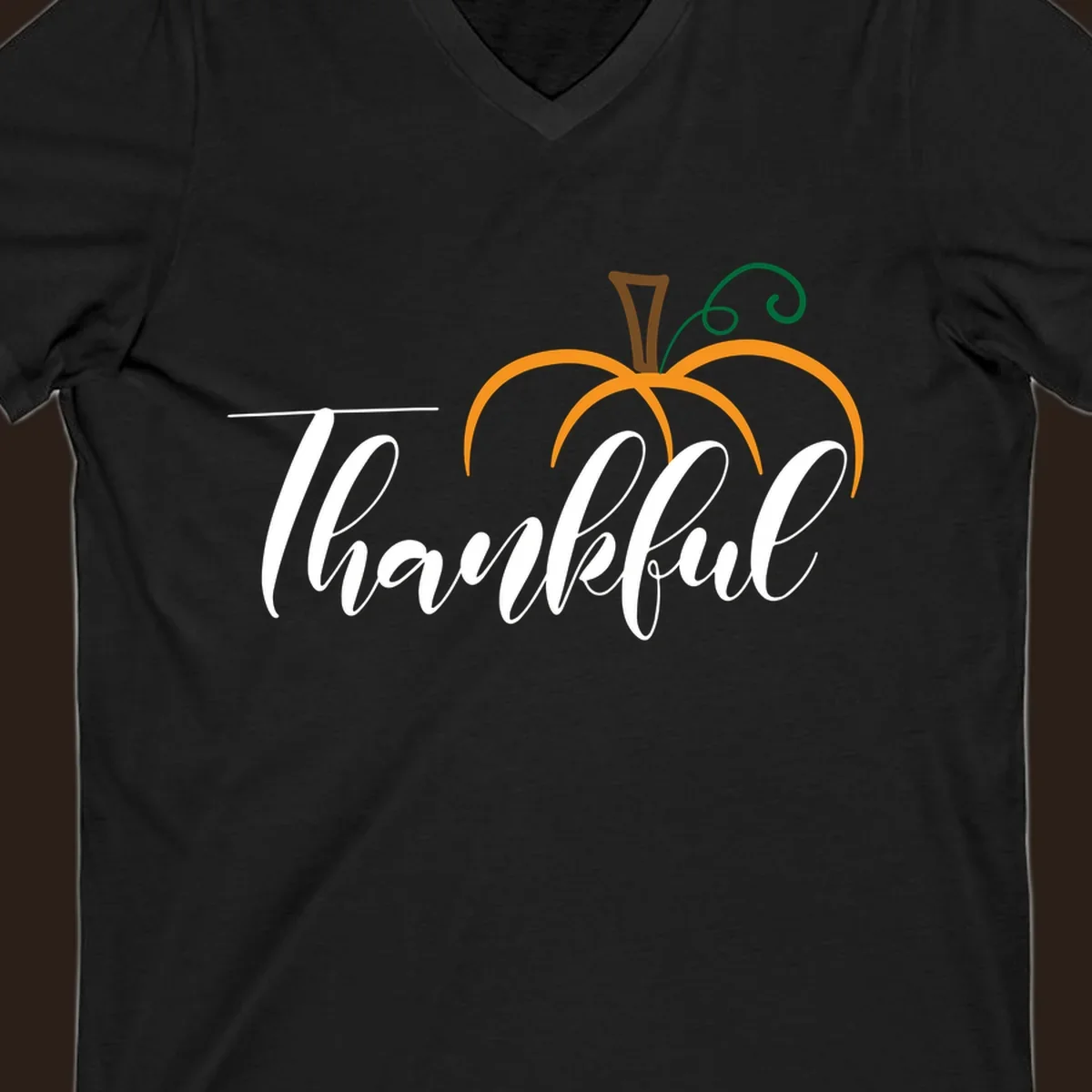 White script text 'Thankful' with a stylized orange pumpkin illustration.