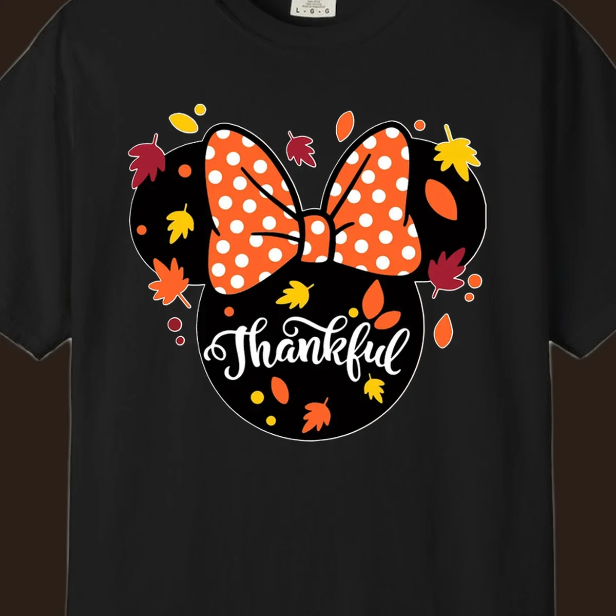 Minnie Mouse silhouette with polka dot bow and fall leaves, text reads Thankful.