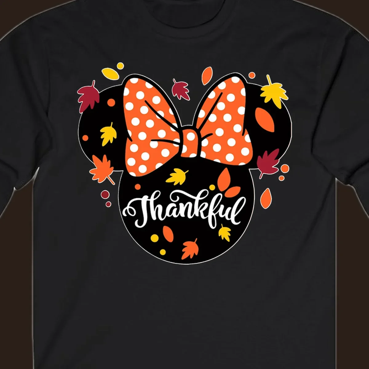 Minnie Mouse silhouette with polka dot bow and fall leaves, text reads Thankful.