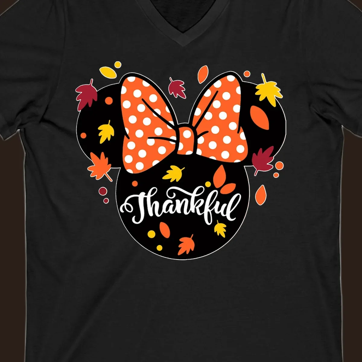 Minnie Mouse silhouette with polka dot bow and fall leaves, text reads Thankful.