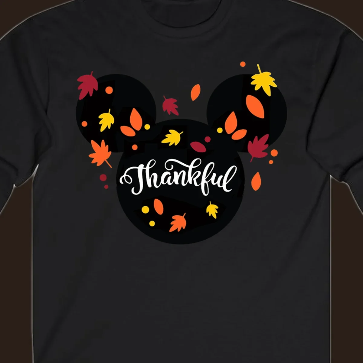 Mickey mouse head silhouette with 'Thankful' text and fall leaves, for thanksgiving shirts.