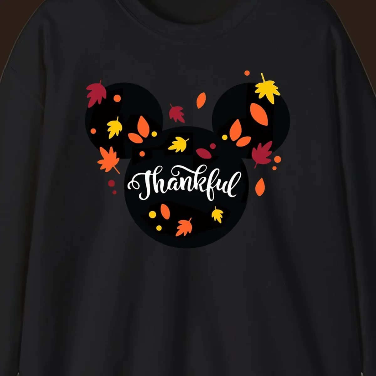 Mickey mouse head silhouette with 'Thankful' text and fall leaves, for thanksgiving shirts.