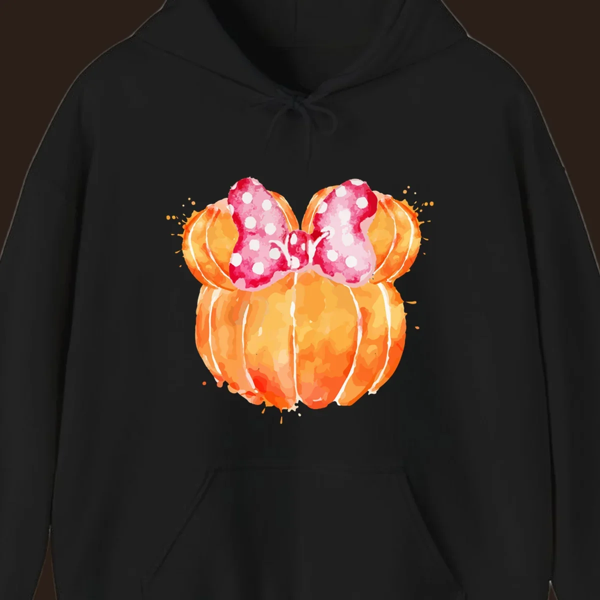 Watercolor illustration of two orange pumpkins shaped like Minnie Mouse ears with a pink polka dot bow.