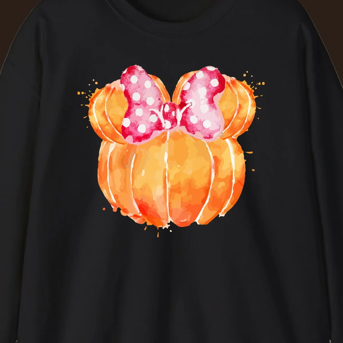 Watercolor illustration of two orange pumpkins shaped like Minnie Mouse ears with a pink polka dot bow.