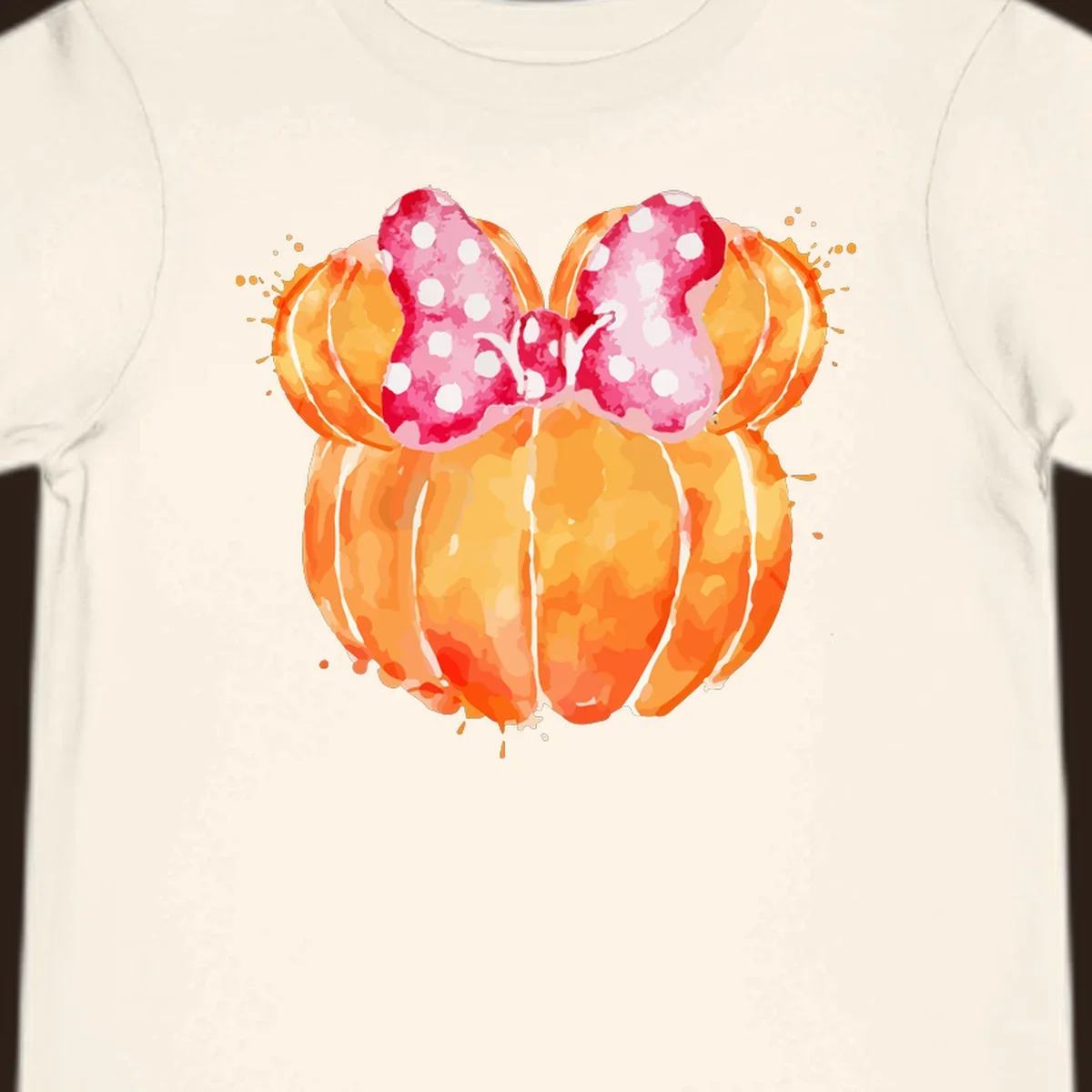 Watercolor illustration of two orange pumpkins shaped like Minnie Mouse ears with a pink polka dot bow.
