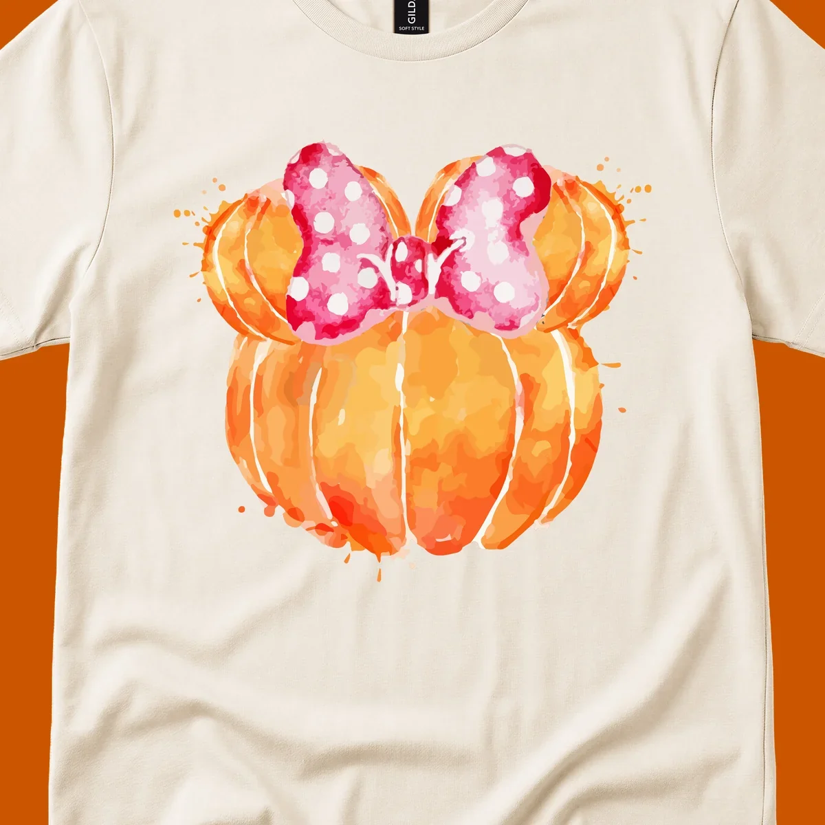 Watercolor illustration of two orange pumpkins shaped like Minnie Mouse ears with a pink polka dot bow.