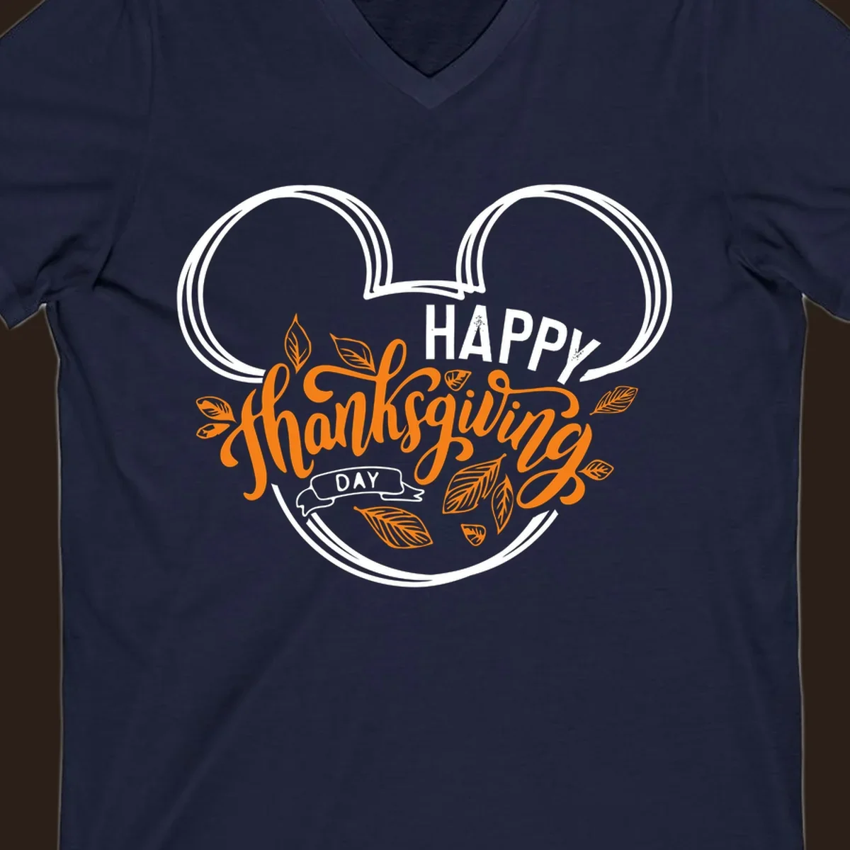 Happy Thanksgiving Day text with Mickey Mouse ears and fall leaves.