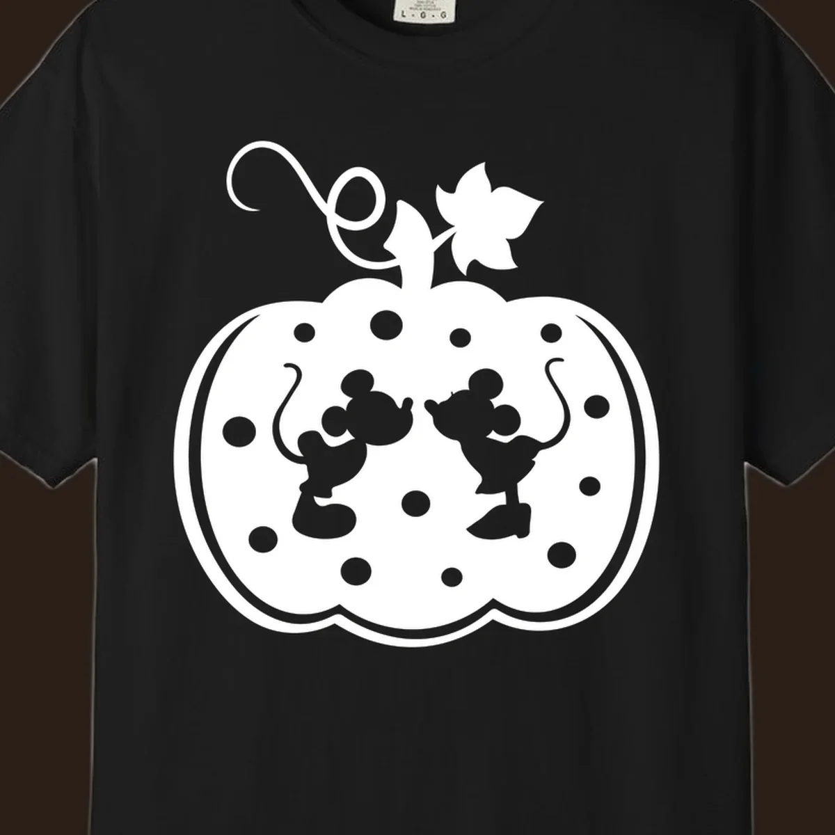 Mickey and Minnie Mouse kissing inside a pumpkin silhouette, with polka dots. Mickey-Minnie-pumpkin.