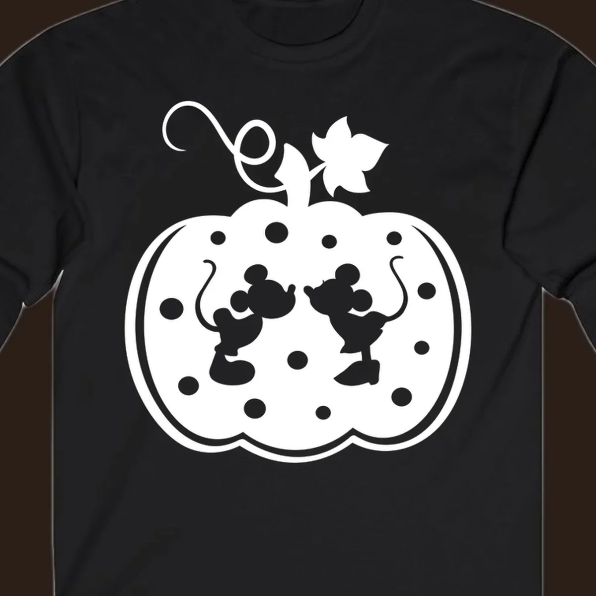 Mickey and Minnie Mouse kissing inside a pumpkin silhouette, with polka dots. Mickey-Minnie-pumpkin.