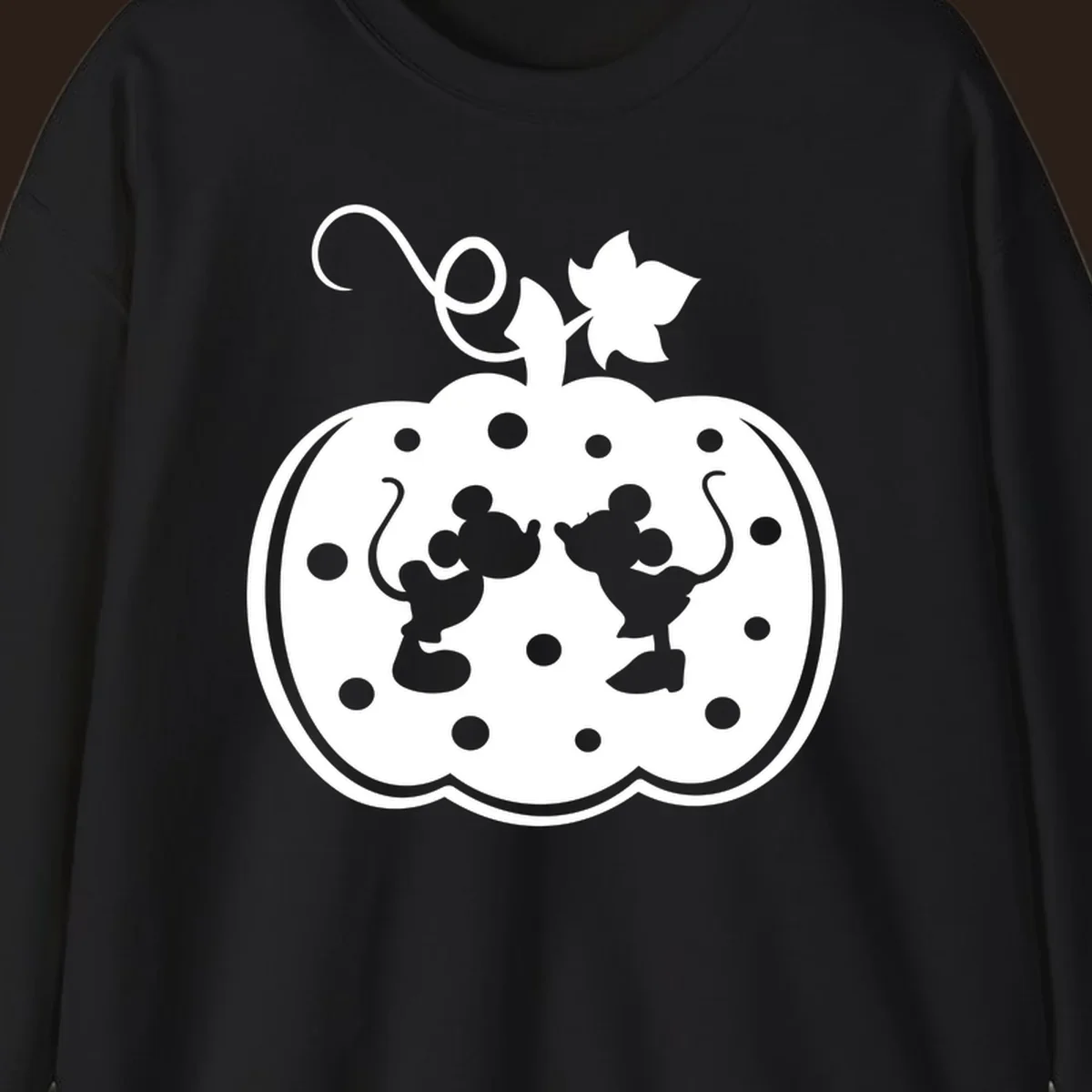 Mickey and Minnie Mouse kissing inside a pumpkin silhouette, with polka dots. Mickey-Minnie-pumpkin.