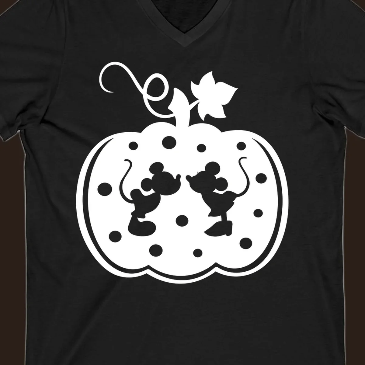 Mickey and Minnie Mouse kissing inside a pumpkin silhouette, with polka dots. Mickey-Minnie-pumpkin.
