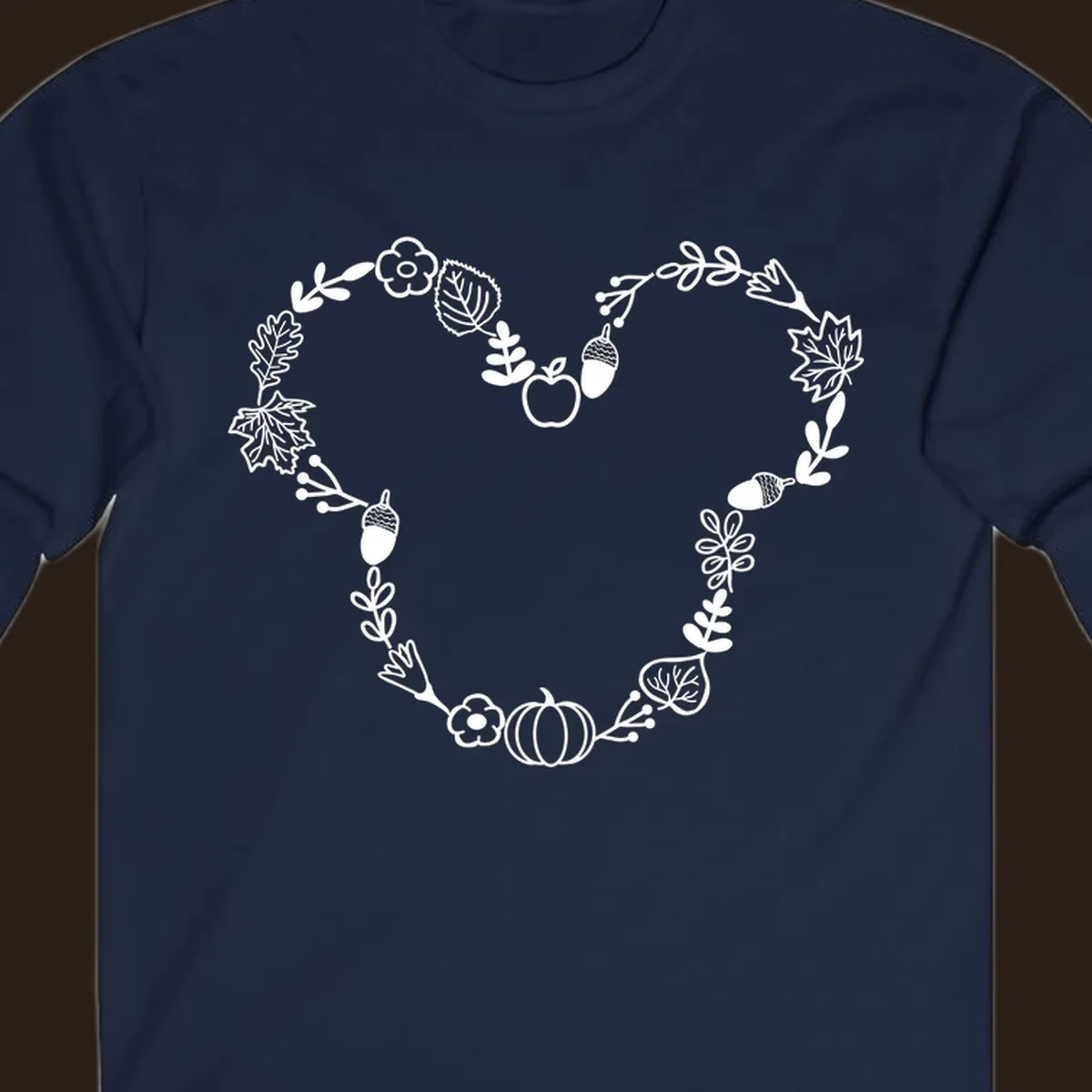 Heart shaped autumn wreath with leaves, acorns, pumpkin, and flowers. Outline design.