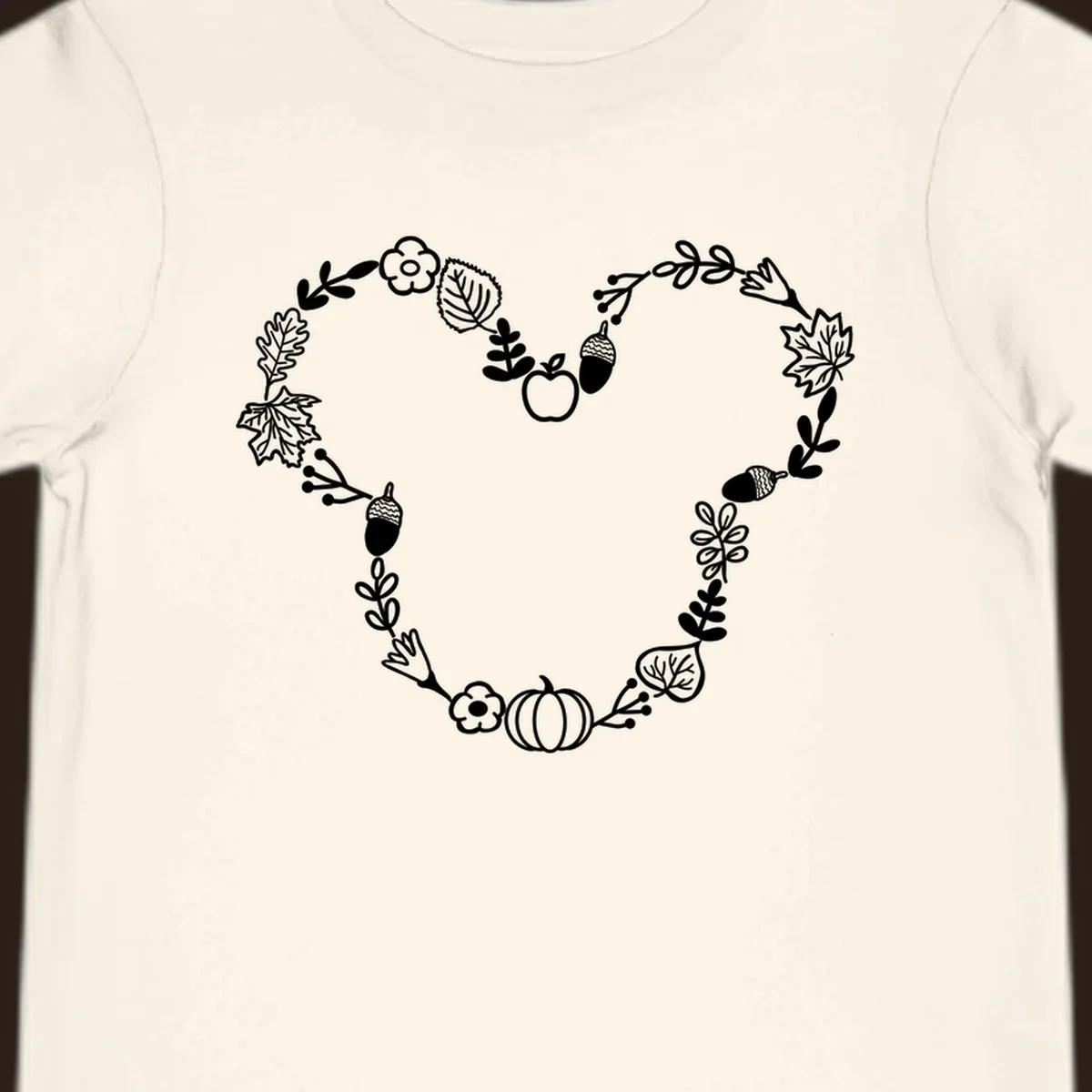 Heart shaped autumn wreath with leaves, acorns, pumpkin, and flowers. Outline design.