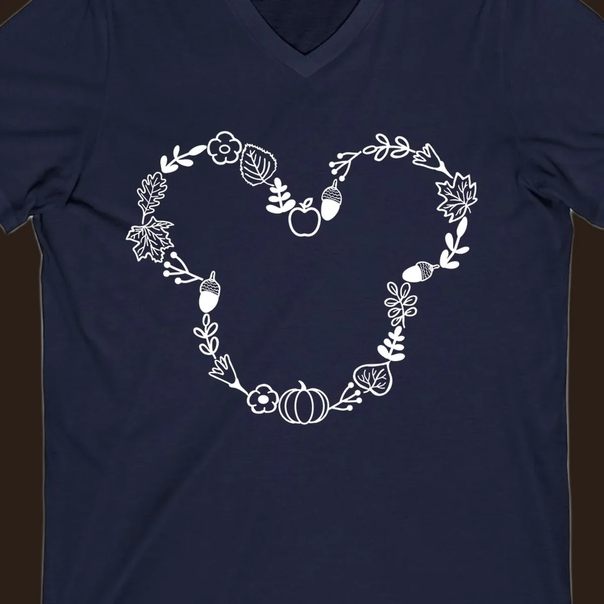 Heart shaped autumn wreath with leaves, acorns, pumpkin, and flowers. Outline design.