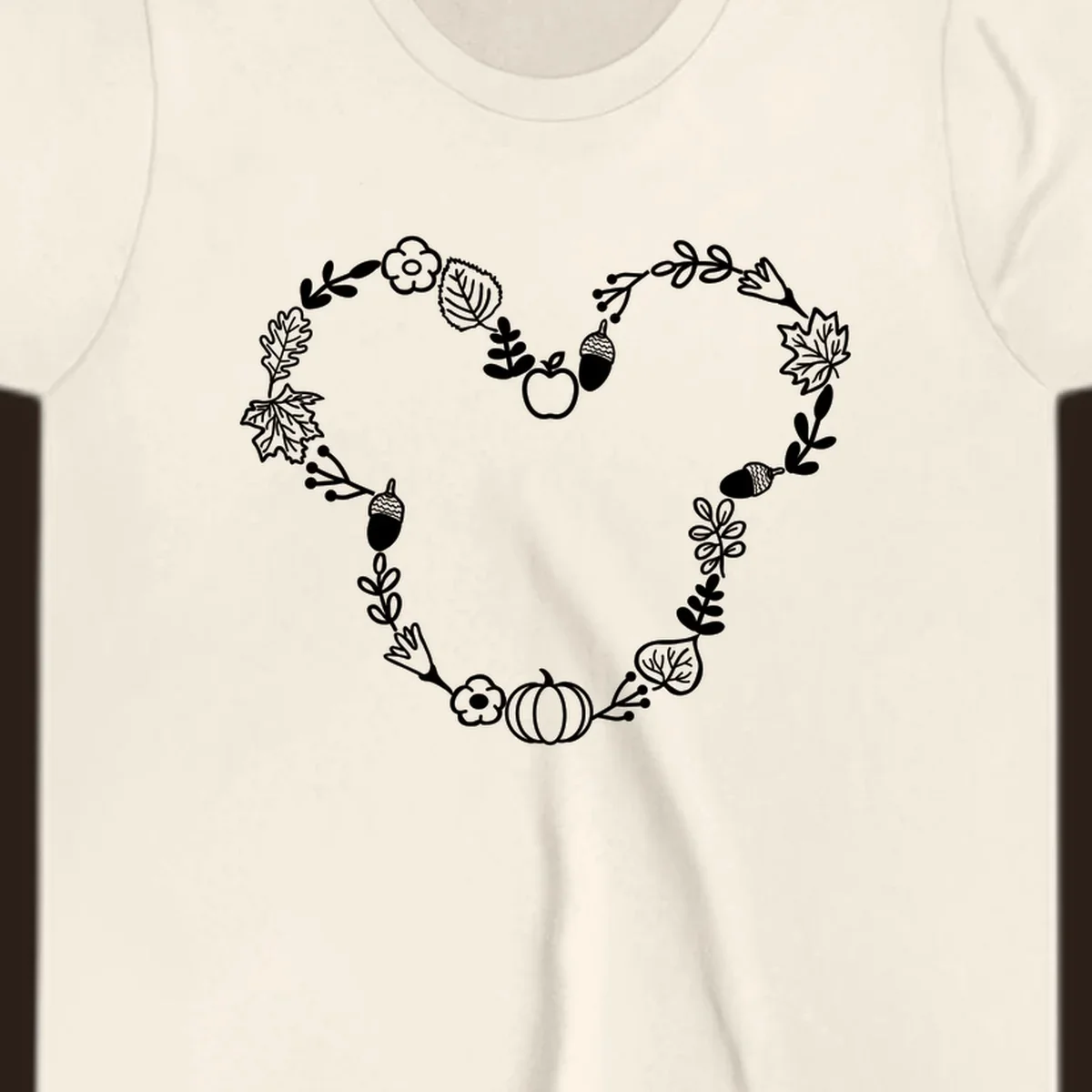 Heart shaped autumn wreath with leaves, acorns, pumpkin, and flowers. Outline design.