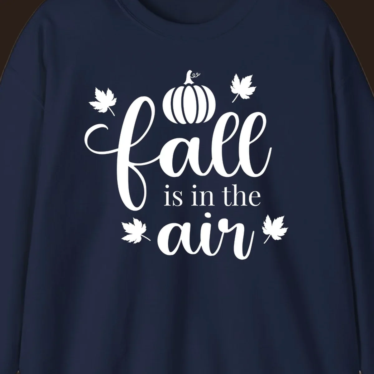 Fall is in the air phrase with pumpkin and maple leaves graphic.