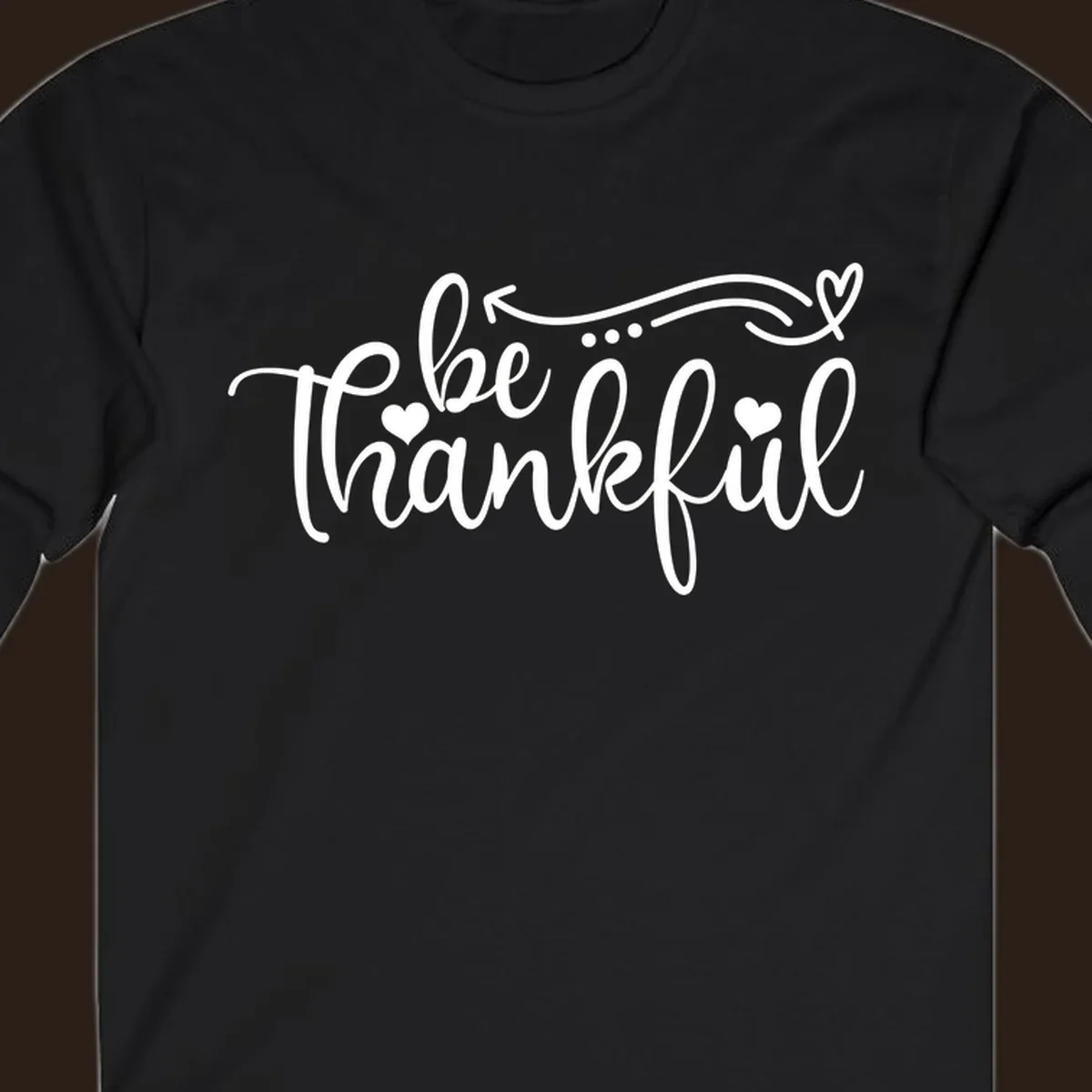 White script text 'be thankful' with hearts and decorative swirls for Thanksgiving.