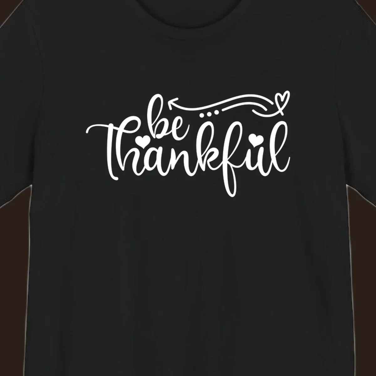 White script text 'be thankful' with hearts and decorative swirls for Thanksgiving.