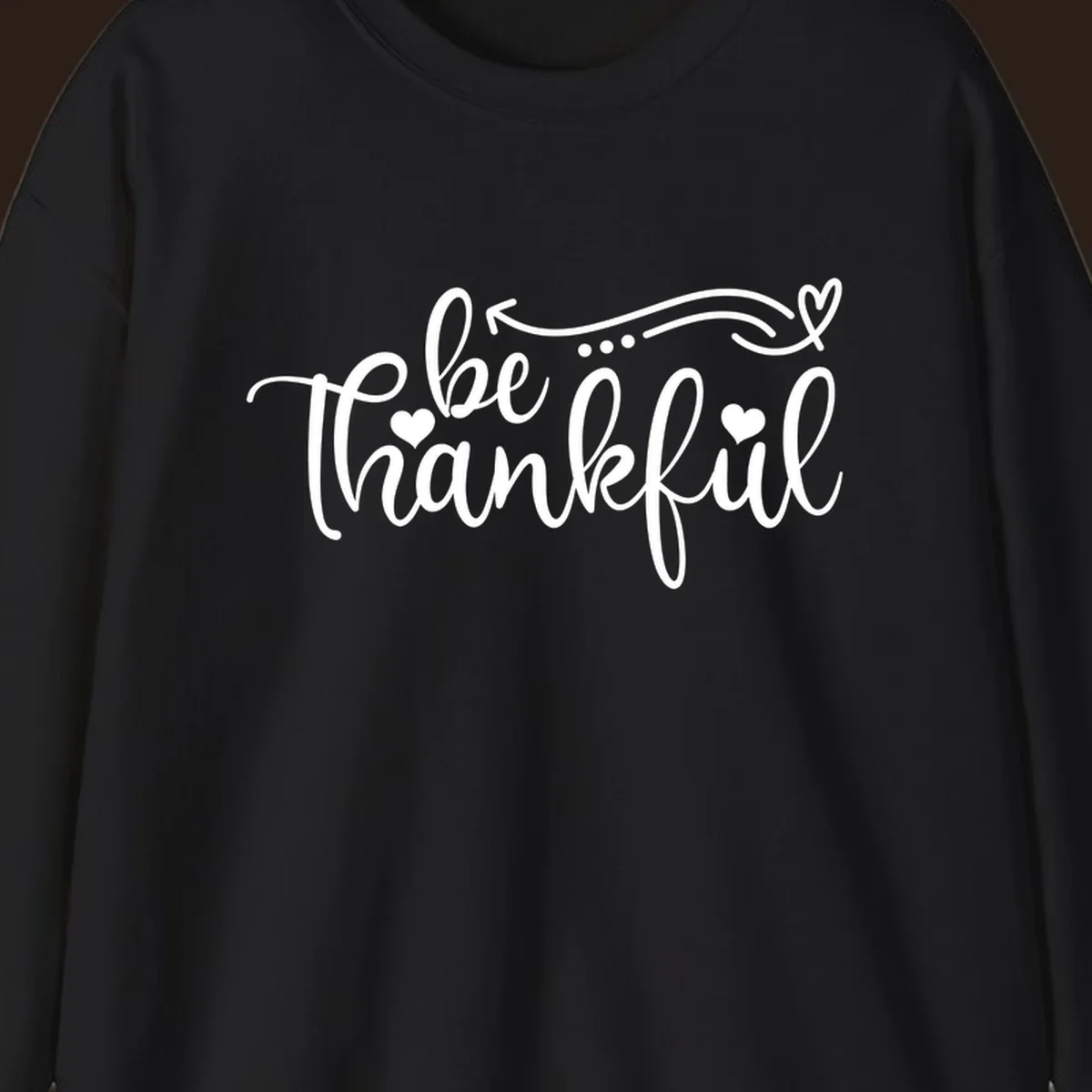 White script text 'be thankful' with hearts and decorative swirls for Thanksgiving.