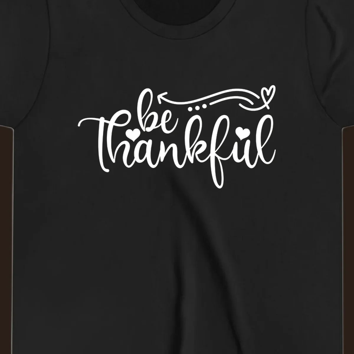 White script text 'be thankful' with hearts and decorative swirls for Thanksgiving.