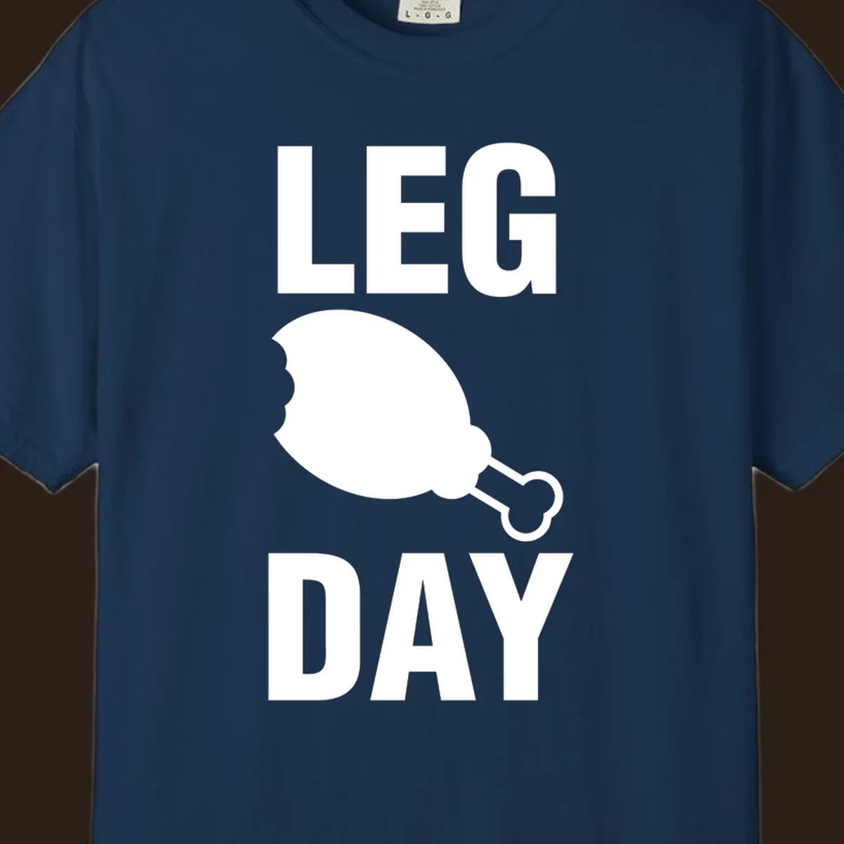 Leg Day text with a bitten chicken leg graphic. Humor fitness design.