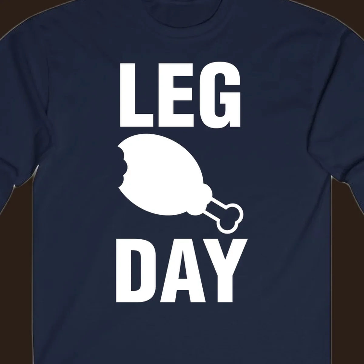 Leg Day text with a bitten chicken leg graphic. Humor fitness design.
