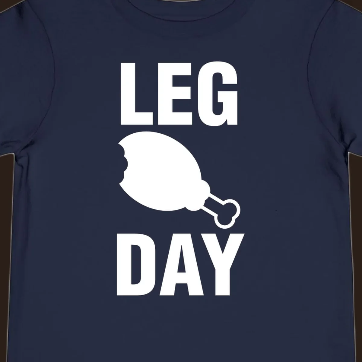 Leg Day text with a bitten chicken leg graphic. Humor fitness design.