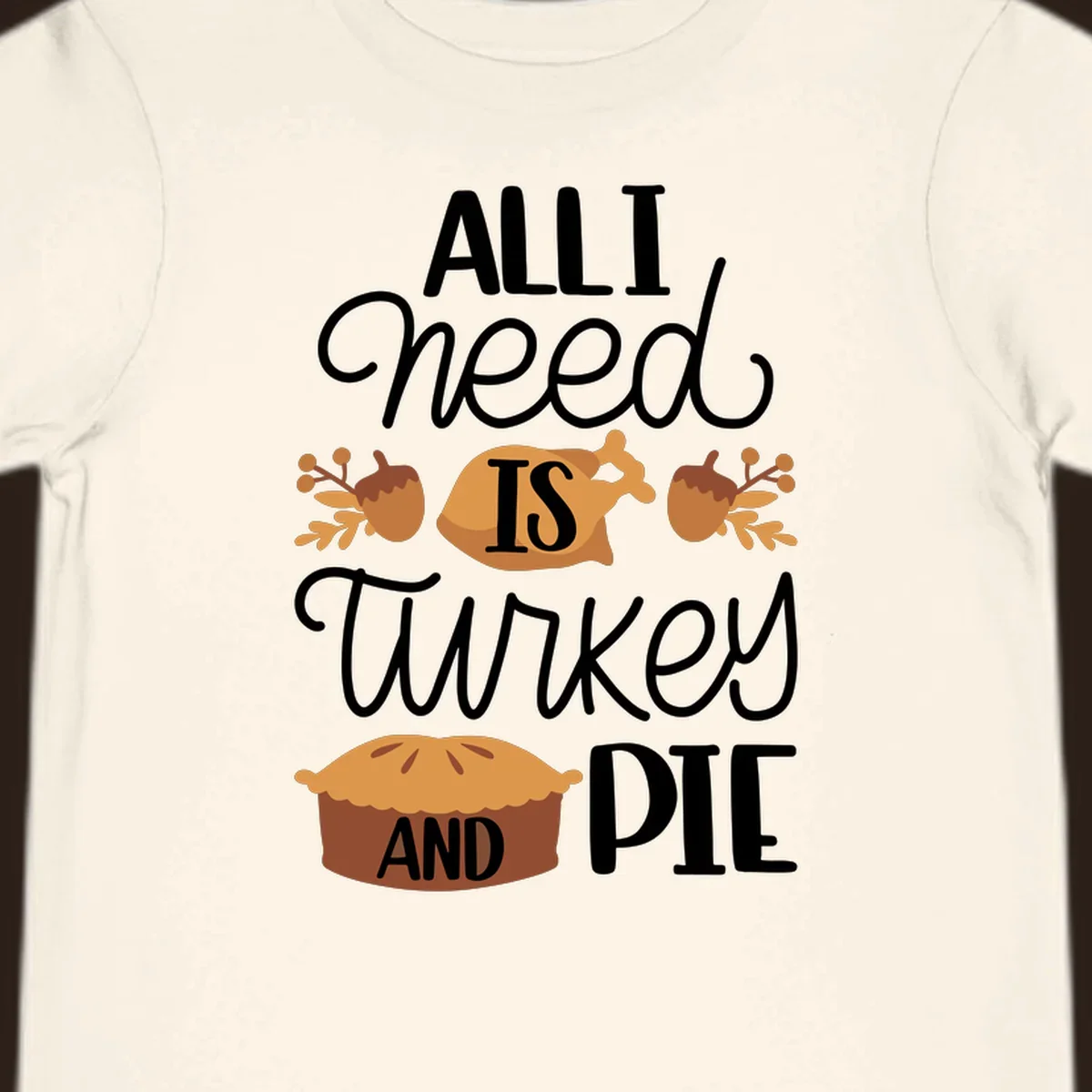 Typography design with illustrations of turkey, pie, and acorns, saying 'ALL I NEED IS TURKEY AND PIE'.