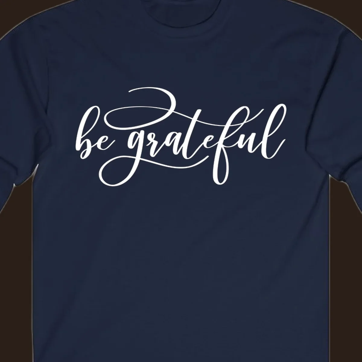 White script text that says 'be grateful' on a black background.
