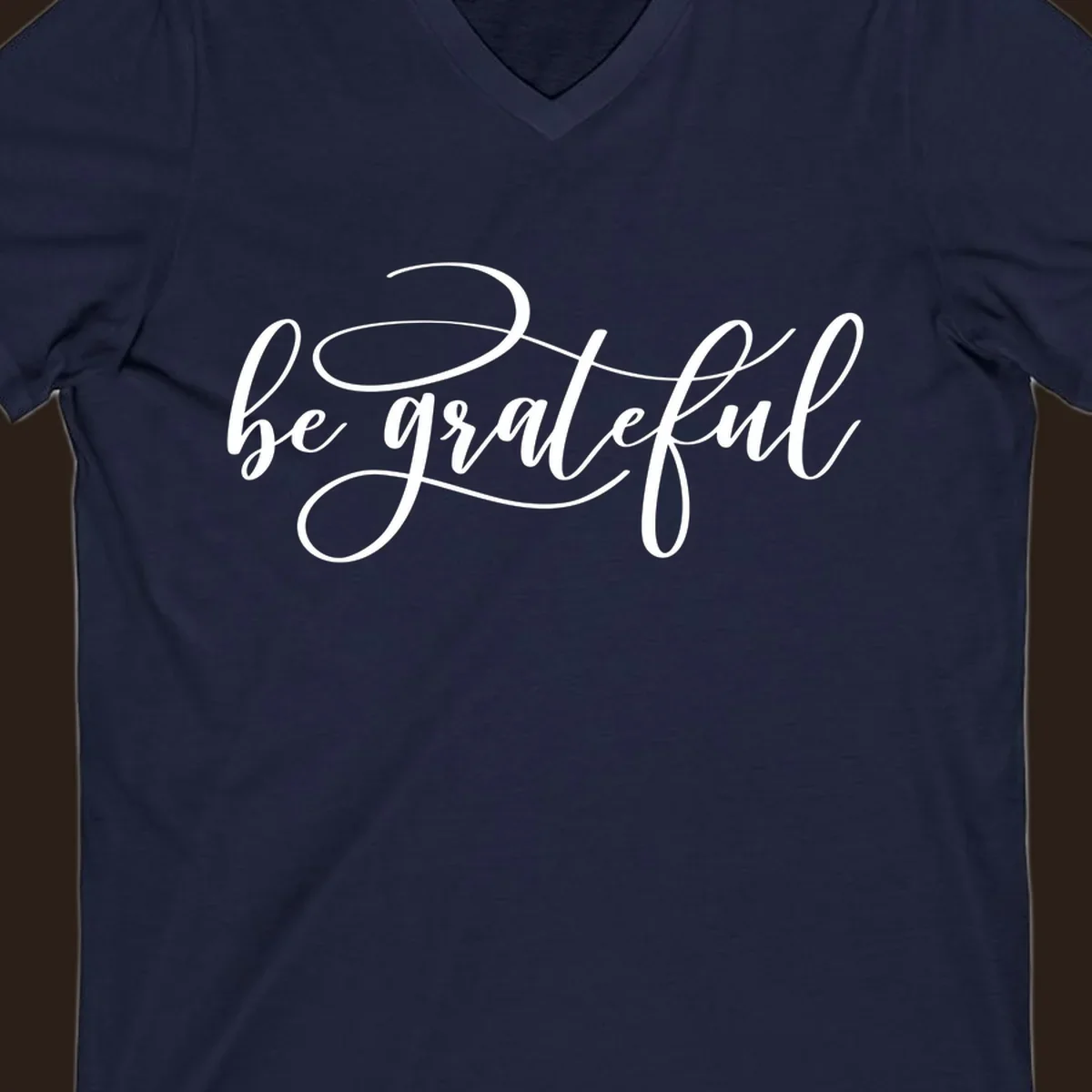 White script text that says 'be grateful' on a black background.