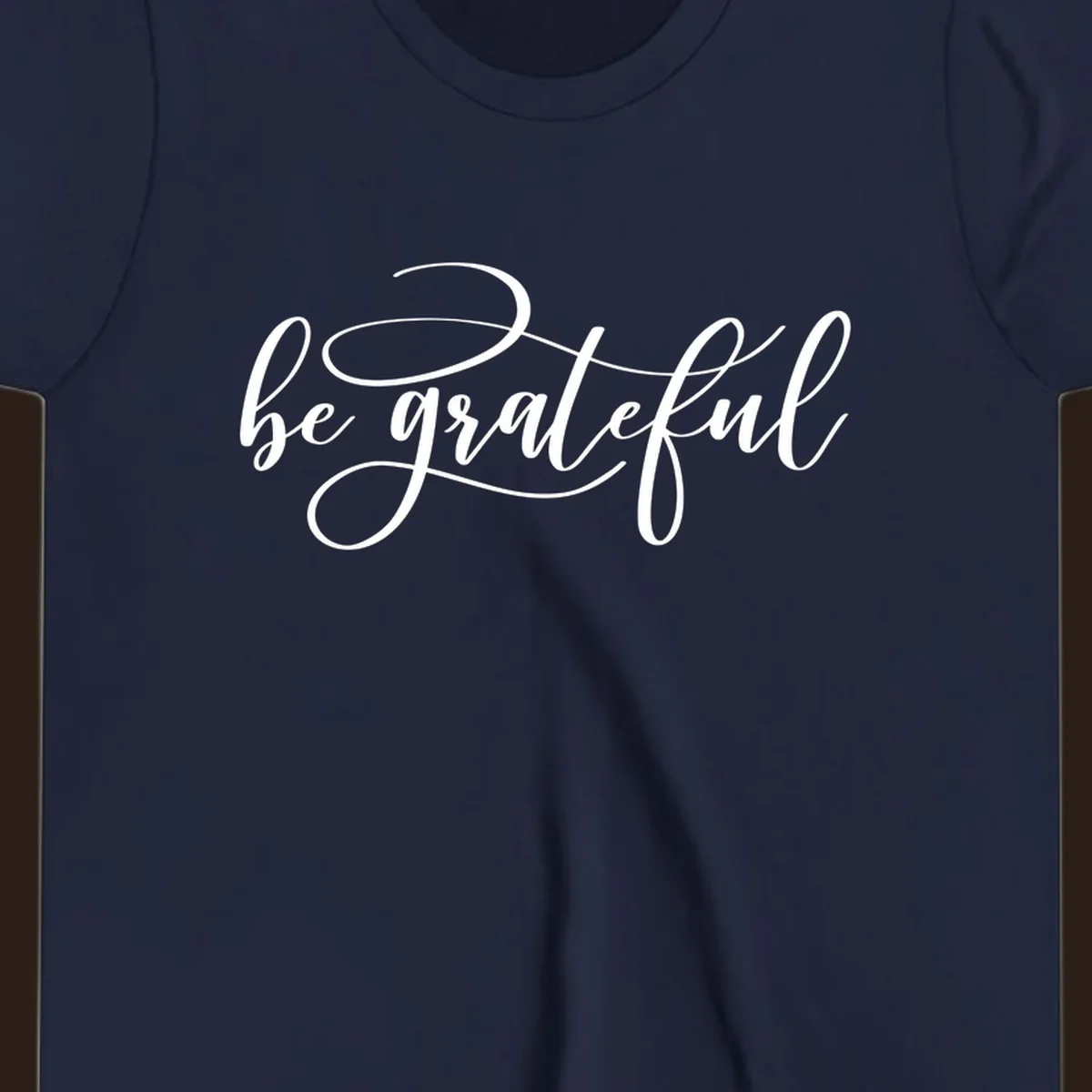 White script text that says 'be grateful' on a black background.