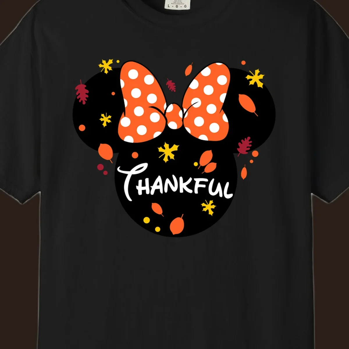 Minnie Mouse silhouette with polka dot bow and 'THANKFUL' text, surrounded by fall leaves.