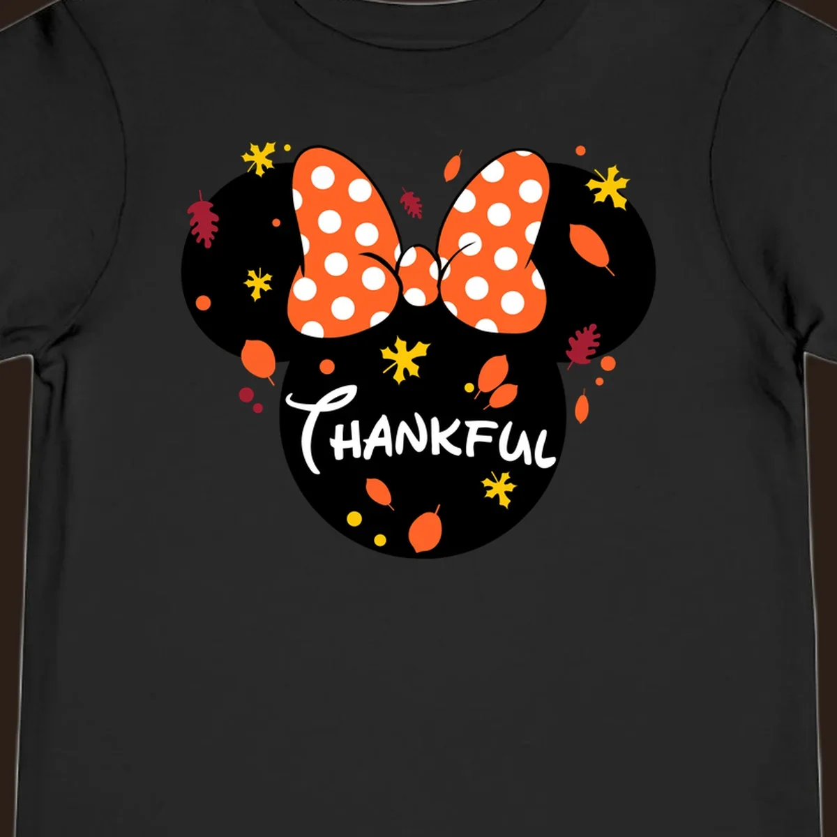 Minnie Mouse silhouette with polka dot bow and 'THANKFUL' text, surrounded by fall leaves.