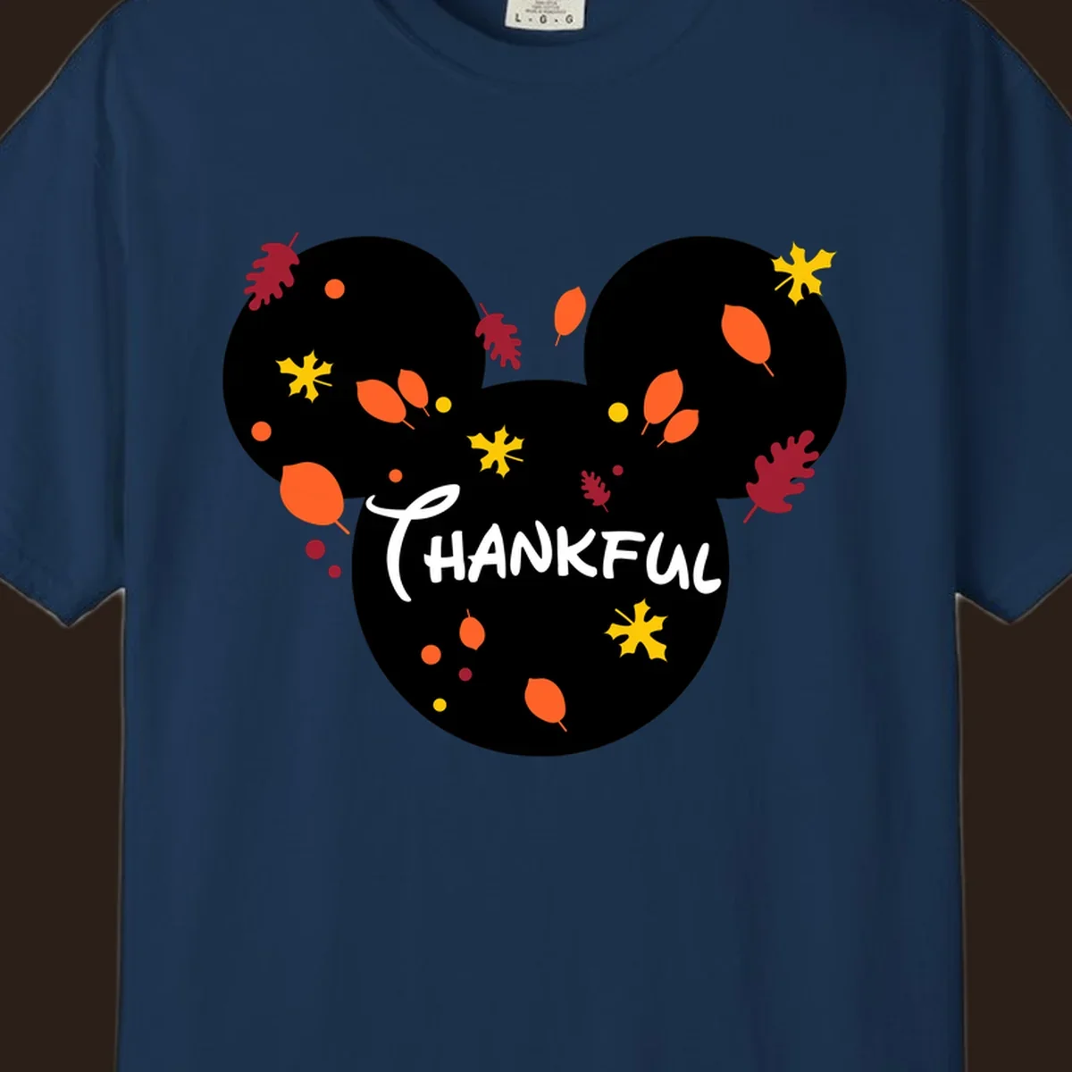 Mickey ears shape with fall leaves and the word THANKFUL in white text.