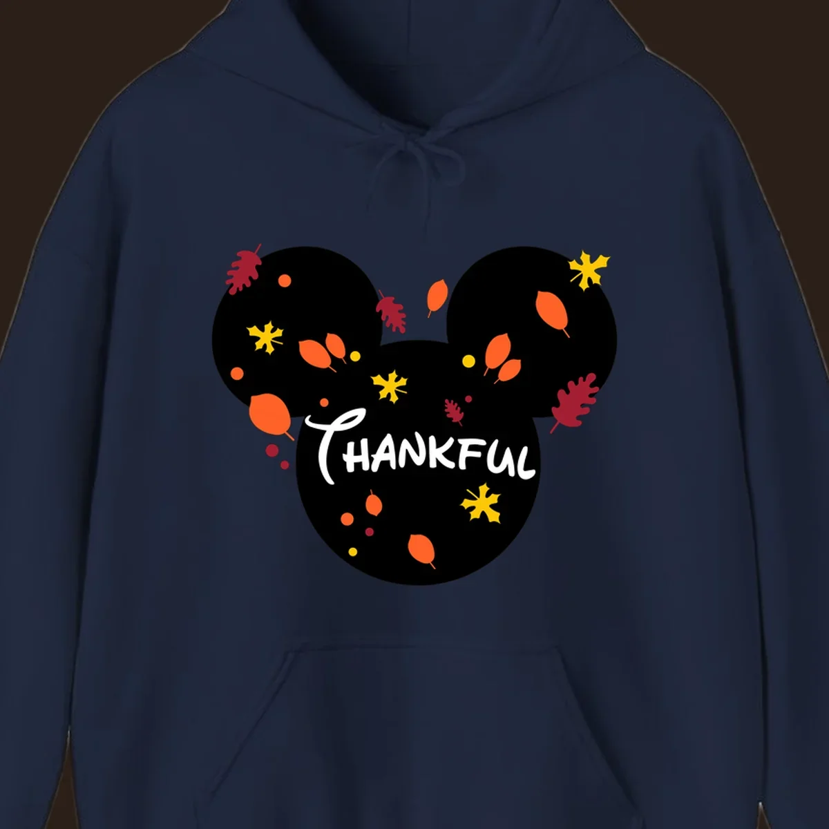 Mickey ears shape with fall leaves and the word THANKFUL in white text.