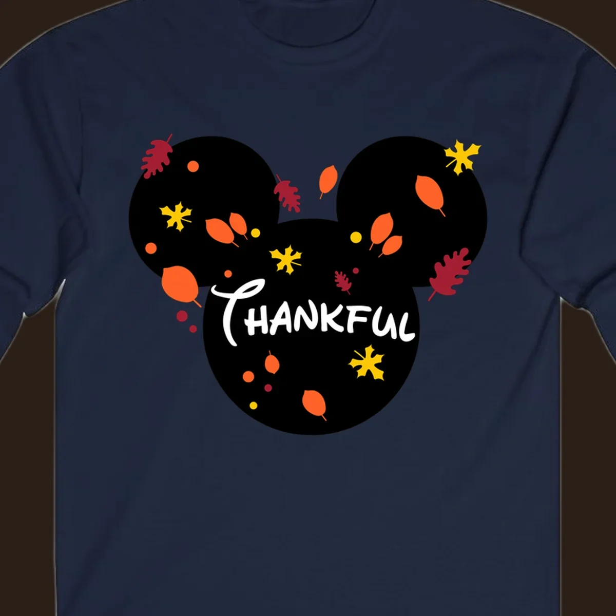 Mickey ears shape with fall leaves and the word THANKFUL in white text.